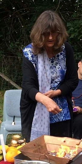 Vikki Koplick (Devaki Ma) offering flower petals in a group fire ceremony at Shanti Mission